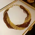 Detailed view of an elegant bohemian multi-layered seed bead necklace in brown and gold - Multilayer Seed Bead Style / Brown