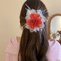 Elegant large red and white rose flower hair clip with feathers worn by a female model - Feather Decorated Rose Hair Clip (21#) / 21# Duckbill Clip - Red