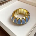 Close-up detail of a French-style marbled light blue and gold geometric elastic bracelet. - Elastic Geometric Style / Gold-Blue