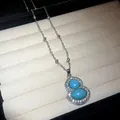 Close-up detail of silver gourd pendant necklace with blue stones and sparkling crystals - Necklace / Silver-Blue