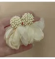 Primo piano di eleganti orecchini a fiore in perline beige e tessuto organza in mano - Fiore in Filato di Perline (Perno in Argento)
