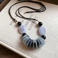 Vue détaillée d'un collier rétro de style ethnique avec perles en résine marbrée - Transparent
