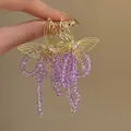 Macro detail of elegant gold butterfly earrings with long purple faceted beaded tassels - Hollow Butterfly with Purple Seed Bead Tassel (12#)