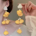 Elegant yellow flower tassel earrings featuring pearls in a sweet dopamine style. - Bud Style
