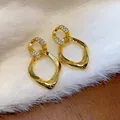 Vista detallada de los elegantes pendientes de circonita dorados con diseño de rombo - Rombo Retorcido Patchwork (WE5068) / Dorado