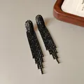 Macro view of black rhinestone long tassel earrings with sparkling dangling strands - Arch Tassel (HE22357) / Gunmetal