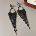 Close-up of sparkling black rhinestone tassel earrings with silver needle post. - Teardrop Tassel (HE22357) / Gunmetal