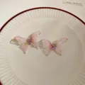 Eleganti orecchini a farfalla rosa con zirconi scintillanti su un piatto di ceramica - Farfalla in Rete Rosa (38)