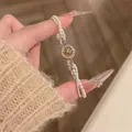 Vue détaillée d'un élégant bracelet en perles avec un pendentif étoile en zircon circulaire. - Or-Blanc