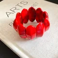 Vista dettagliata di un bracciale elastico in acrilico rosso marmorizzato con perle ovali - Stile Lavaggio Inchiostro Ovale / Rosso