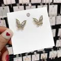 Eleganti orecchini a lobo a farfalla con zirconi su cartoncino bianco da esposizione. - Farfalla in Strass Oro (61)