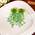 Handmade green seed bead tassel earrings with blue accents on a white plate - Green-Blue Seed Bead Woven Tassel (87#)