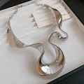 Gros plan d'un collier ruban métallique argenté poli au design irrégulier et fluide - Choker (WN1903) / Argent