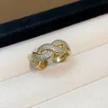 Primo piano di un anello intrecciato placcato oro con micro pavé di zirconi cubici - Stile Avvolto Intrecciato