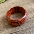 Detailed view of a vintage wooden bangle with unique striped circular wood grain patterns - Style 5