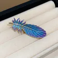 Detail view of an elegant blue and purple gradient enamel feather hair clip - Feather Design / Gold Color Blue