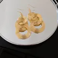 Detailansicht von goldenen minimalistischen mehrlagigen kreisförmigen Drahtohrringen - Ohrhaken / Gold