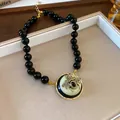 Vintage style black beaded necklace featuring a decorative gold bee coin pendant SKU - Gold-Black