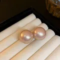 Dettaglio ravvicinato di grandi orecchini a lobo con perle rosa tonde e lucenti - Perno per orecchini in argento - Rosa