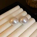 Primo piano di eleganti orecchini a lobo con grandi perle bianche su vassoio velluto - Perno in argento-Bianco