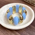 Macro view of a retro elastic bracelet featuring blue marbled acrylic and gold oval segments - Bracelet (HB4271) / Blue