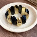 Detailed view of a vintage acrylic stretch bracelet with marbled black and gold oval beads - Bracelet (HB4271) / Black