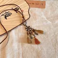 Detail showing ethnic flower pendant with wooden beads and tassels on fabric background. - Flower Pendant (1#)