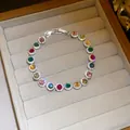 Close-up of sparkling colorful zircon round link bracelet in a grey velvet jewelry box - Round Style / Colorful