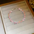Detailed view of a sparkling pink cubic zirconia round halo bracelet in a jewelry box - Round Style / Pink