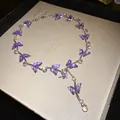 Detailaufnahme einer eleganten lila Glas-Schmetterlingshalskette mit Wassertropfen - Halskette / Silber-Lila