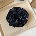 Primo piano di un elastico per capelli floreale vintage nero con piccoli fiori gialli e blu. - Scrunchie / Blu