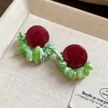 Close-up detail of vintage red stud earrings featuring unique green shell stone chips - Red-Green