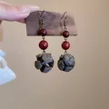 Detailed close-up view of bohemian ethnic earrings featuring red beads and natural nut shells - Style 11 Ear Hook