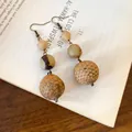 Close-up of vintage bohemian dangle earrings with natural seed and nut beads - Style 21 Ear Hook