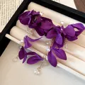 Detailed macro view of elegant purple fabric floral earrings with pearls and crystal dangles - Silver Post Gold Flower Style / Purple