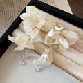 Close-up of elegant white fabric flower earrings with delicate pearl and crystal details - Silver Post Gold Flower Style / Yellow