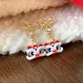 Dettaglio degli orecchini danza del leone in smalto rosso con borchie a fiocco dorato - Perno in Argento-Rosso-Stile 1