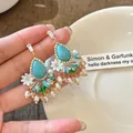 Detailed view of bohemian style dangle earrings with turquoise stones, flowers and pearls - Retro Flower Teardrop Style (HE25609) / Blue (Gold Base)