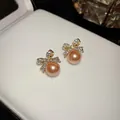 Close-up of elegant bow-knot earrings with sparkling crystals and peach pearls - Bowknot Pearl Earrings