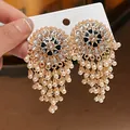 Detailed view of ornate boho vintage round earrings with pearl tassels and crystals - White-Black