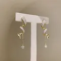 Elegant gold-plated spiral drop earrings with sparkling stars and chain detail - Gold