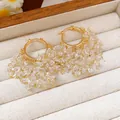 Dettaglio di orecchini a cerchio placcati oro 18k con motivi a stella e frange di cristallo - Orecchini a cerchio con nappine a stella (HE26301) / Oro