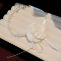 Close-up of an elegant white satin rose and pearl choker necklace with ribbon tie - Pearl Rose Chokers / White