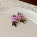 Dettaglio di orecchini a lobo rosa con strass viola e perle eleganti su un piatto bianco - Orecchini (Perno in Argento) / Viola