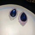 Close-up of oversized blue waterdrop stud earrings with iridescent rhinestone halo. - Silver Needle Studs / Silver-Blue-AB Color