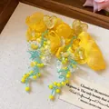 Dettaglio orecchini a nappa con fiori in chiffon giallo e perni a cuore stile resort. - Stile Nappa Cuore Perno Argento / Giallo-Blu