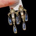 Detailed view of vintage palace style gold drop earrings with dangling blue teardrop crystals - Earring Post Style - Tassel (10#)