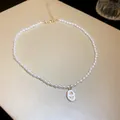 Elegant close-up of a French style pearl necklace featuring a delicate rose pendant charm - White (Tulip/Rose)