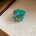 Close-up of a chunky green resin ring decorated with colorful faceted rhinestones - Green