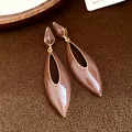 Close-up of Maillard brown enamel water drop dangle earrings with gold hollow design. - Brown
